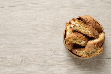 Traditional Italian almond biscuits (Cantucci) on white wooden table, top view. Space for text