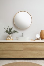 Photo of Modern bathroom interior with stylish mirror, eucalyptus branches and vessel sink