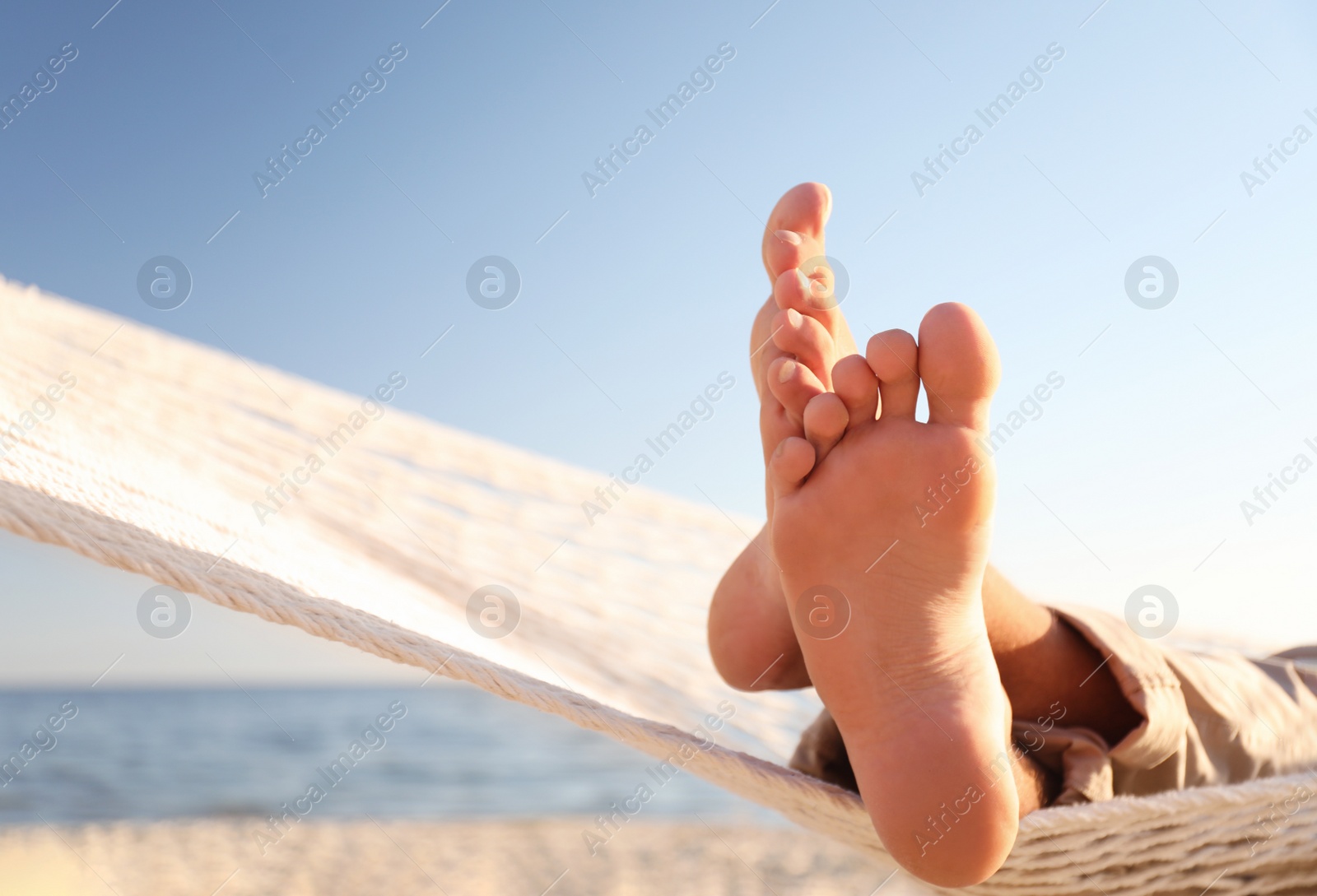 Photo of Man relaxing in hammock on beach, closeup