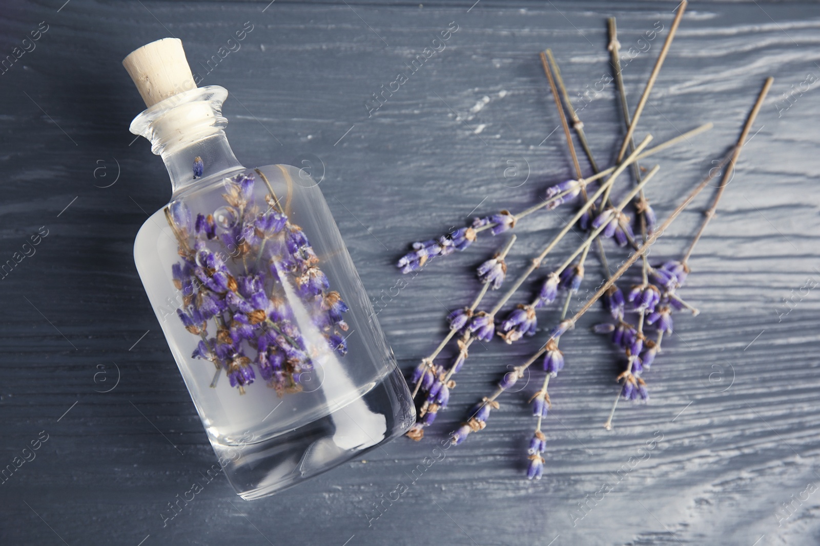 Photo of Flat lay composition with natural herbal oil and lavender flowers on wooden background