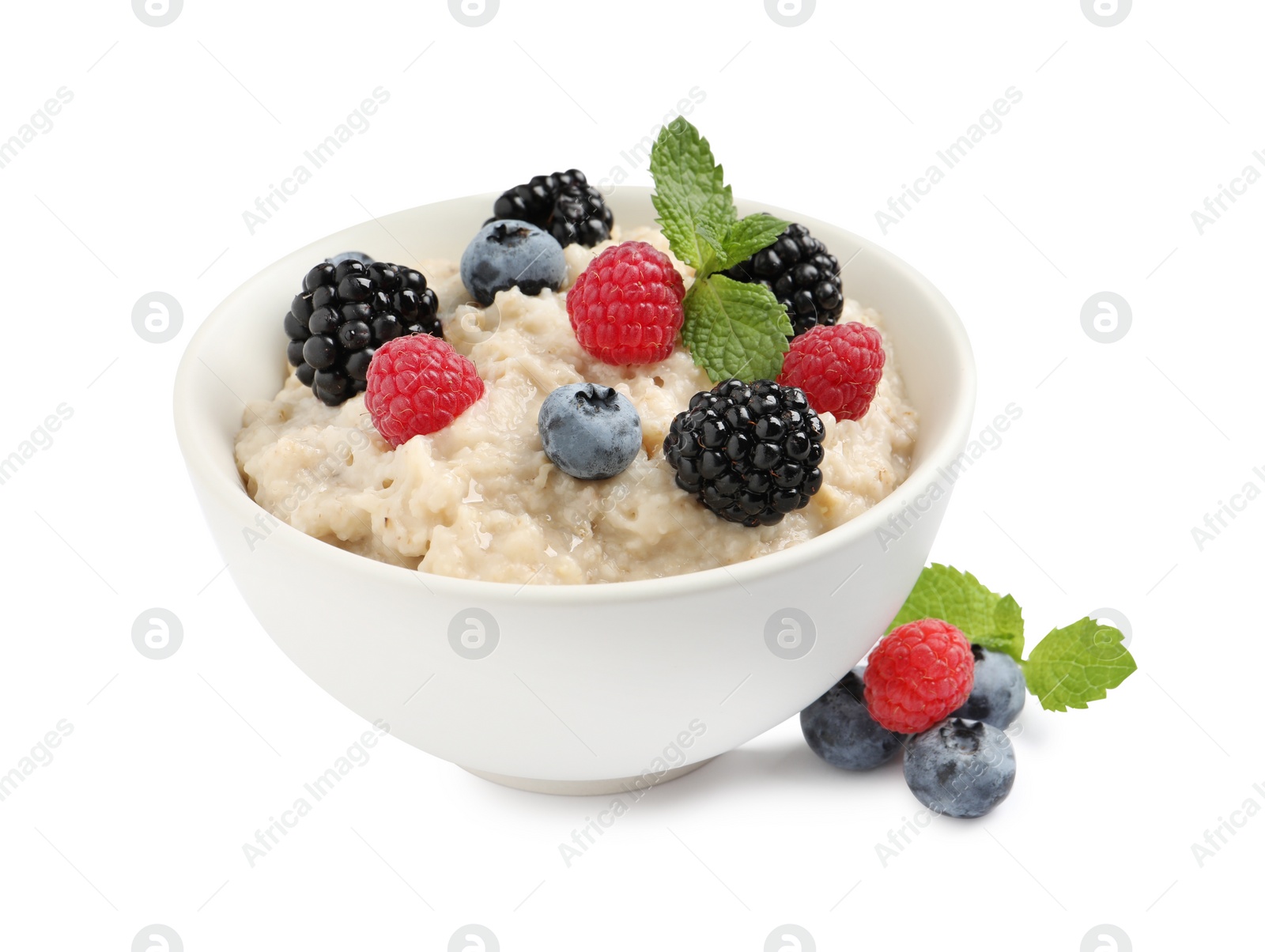 Photo of Tasty oatmeal porridge with blackberries, raspberries and blueberries in bowl on white background