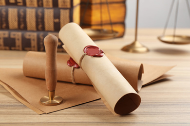 Notary's public pen and documents with wax stamp on wooden table, closeup