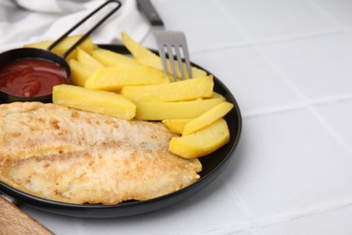Photo of Delicious fish and chips served on white tiled table, closeup