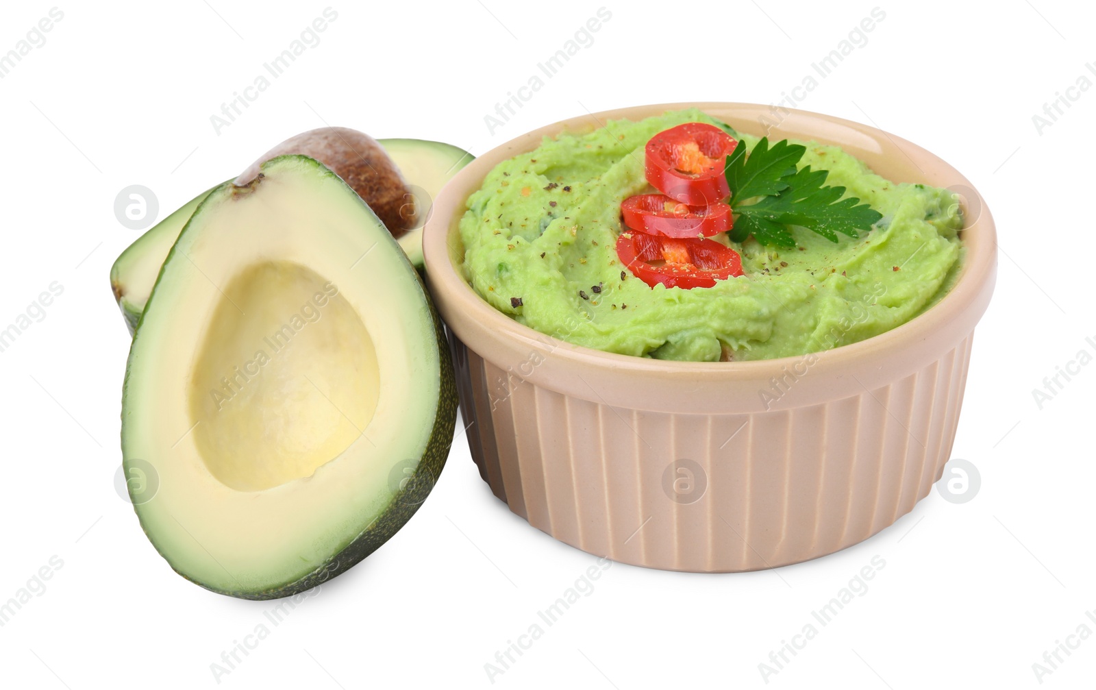 Photo of Bowl of delicious guacamole with chili pepper and fresh avocado isolated on white