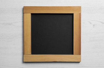 Photo of Blank chalkboard on white wooden background, top view. Space for text