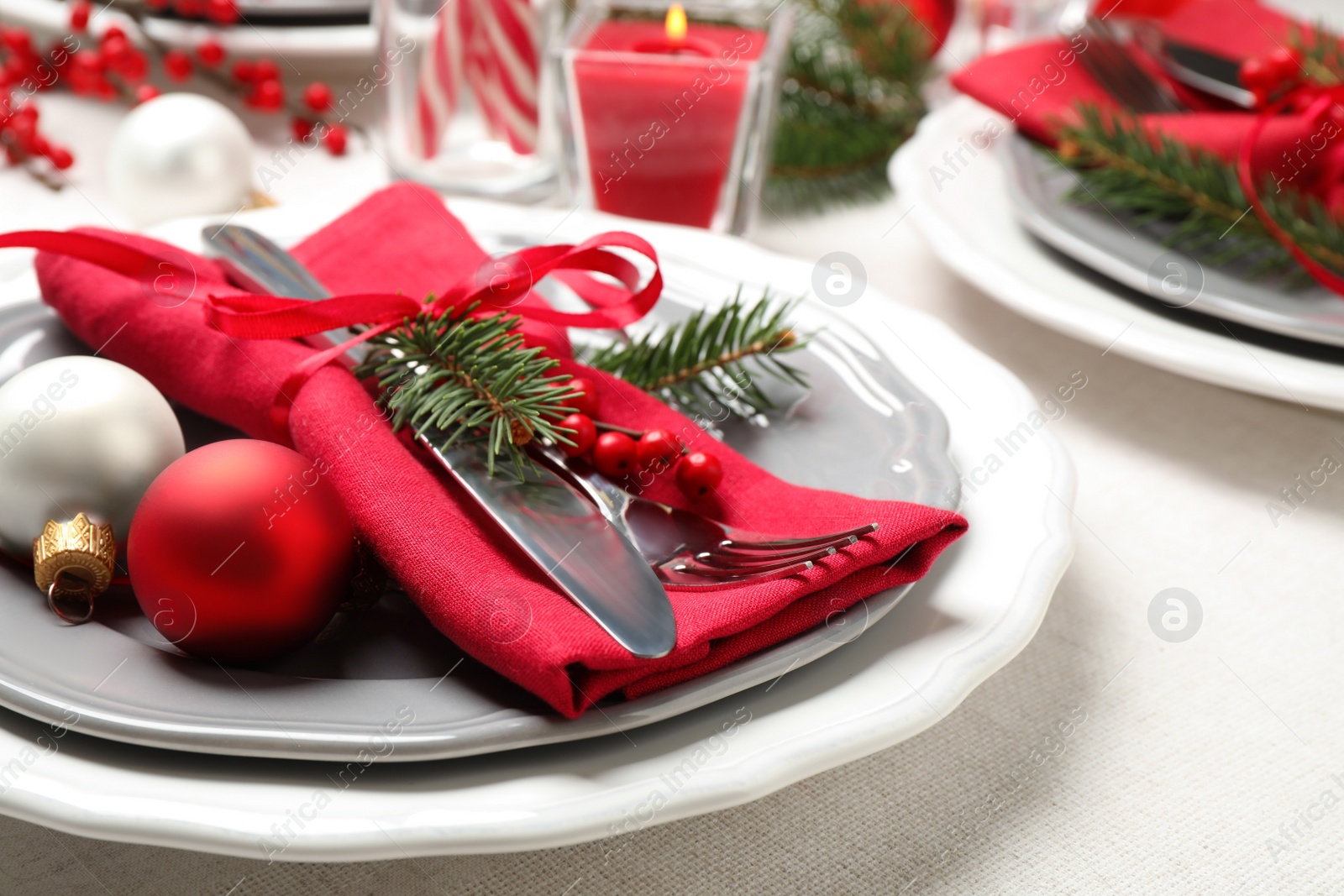 Photo of Festive table setting with beautiful dishware and Christmas decor on white background