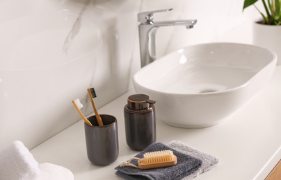 Toiletries and stylish vessel sink on light countertop in modern bathroom