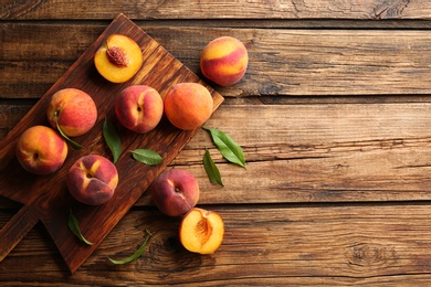 Photo of Fresh sweet peaches on wooden table, flat lay. Space for text