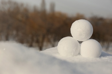 Photo of Perfect round snowballs on snow outdoors, closeup. Space for text