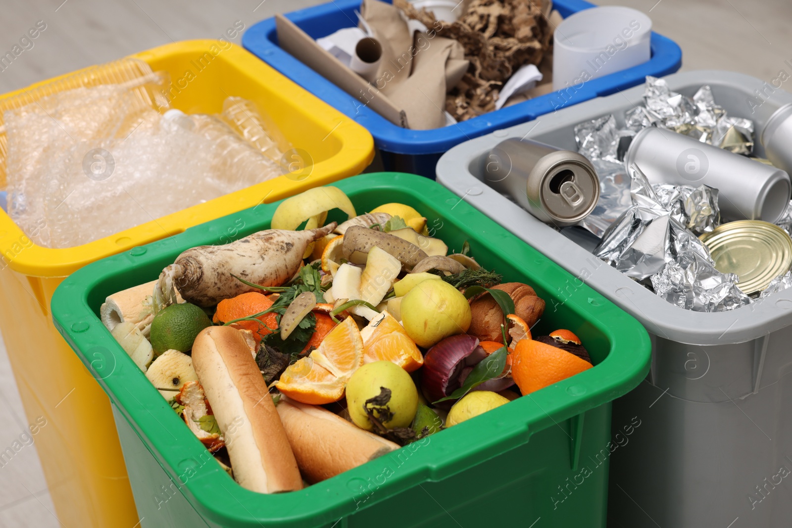 Photo of Garbage sorting. Full trash bins for separate waste collection indoors, closeup