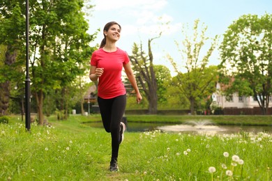 Photo of Young woman jogging around park in morning