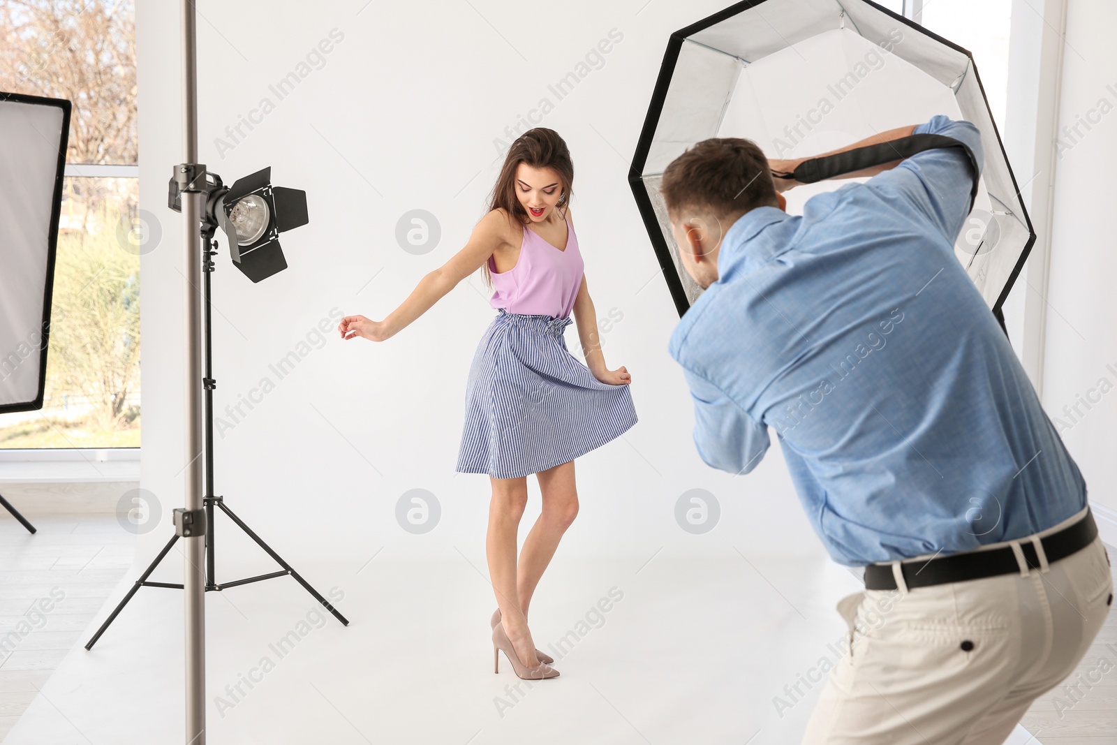 Photo of Beautiful young model posing for professional photographer in studio