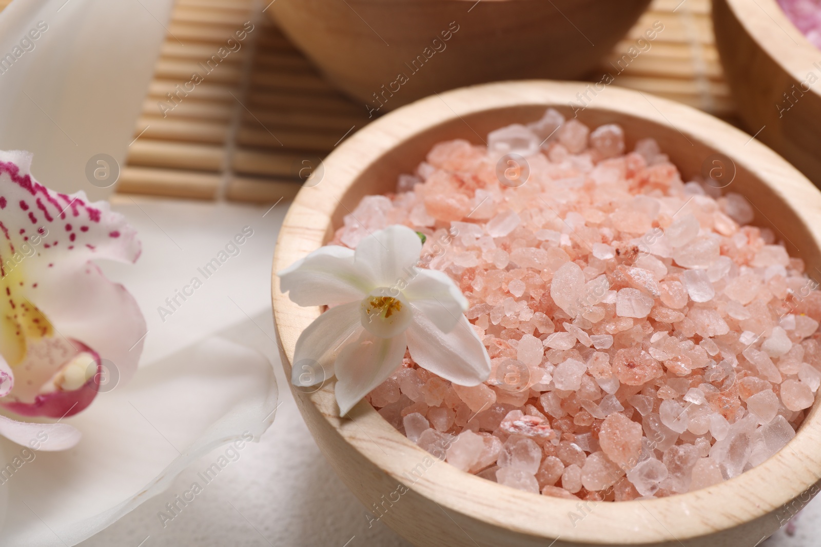 Photo of Spa composition with sea salt and flowers on light grey table, closeup