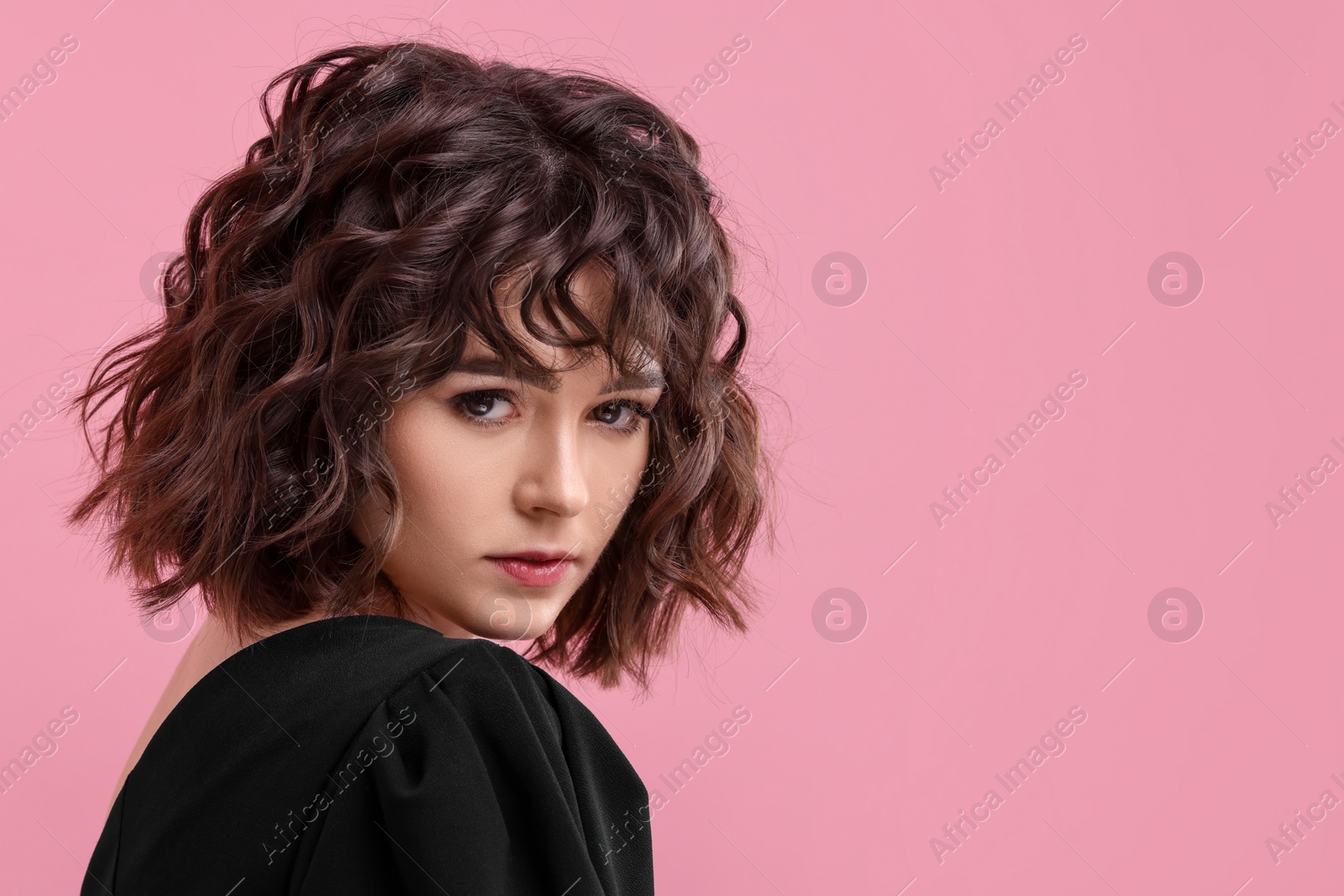 Photo of Portrait of beautiful young woman with wavy hairstyle on pink background. Space for text