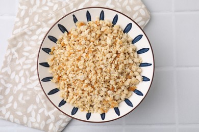 Fried ground meat in bowl on white tiled table, top view