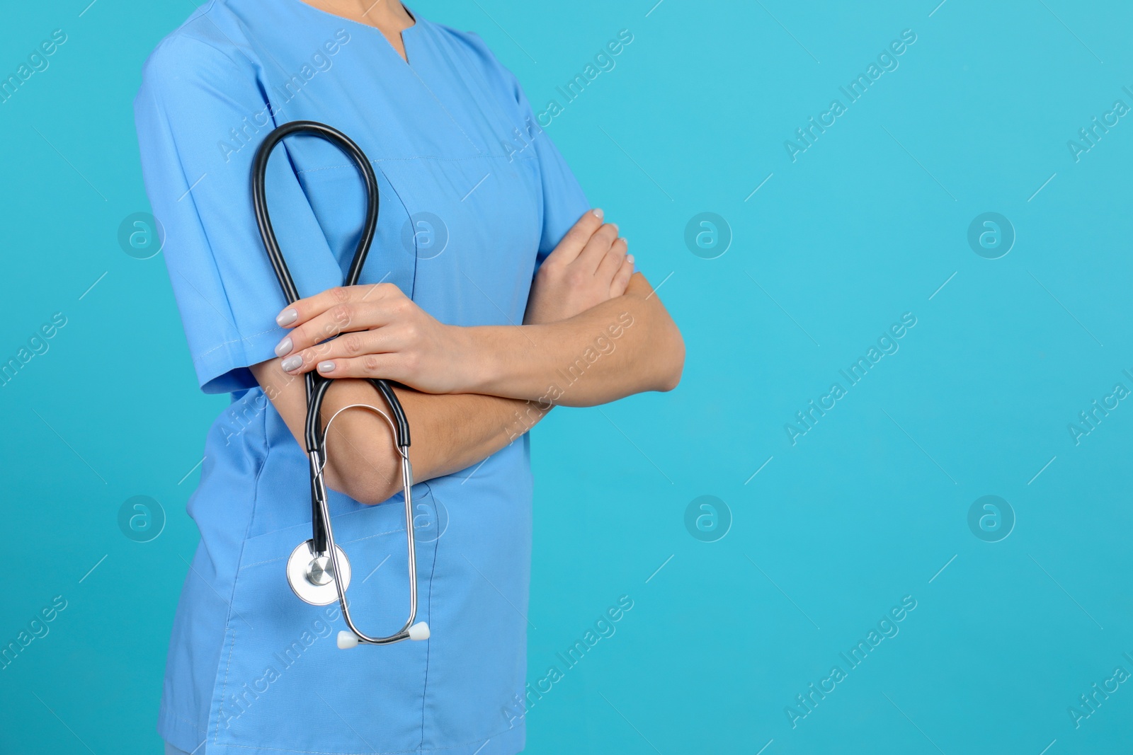 Photo of Medical assistant with stethoscope on color background, closeup. Space for text