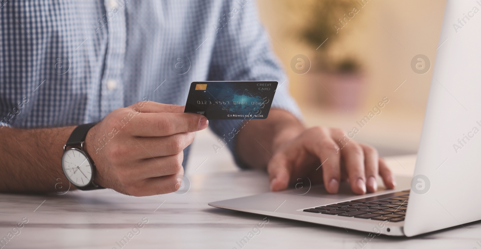 Image of Man with credit card using laptop for online payment at table, closeup. Banner design