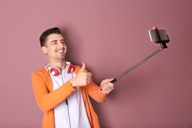 Photo of Handsome man taking selfie against color background