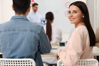 Photo of Happy woman at desk in class during lesson in driving school