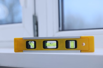 Photo of Yellow building level on white windowsill indoors