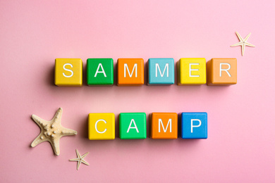 Photo of Colorful wooden cubes with phrase SUMMER CAMP on pink background, flat lay