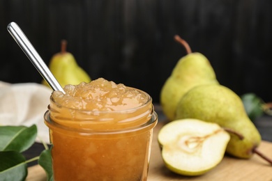 Photo of Delicious pear jam in glass jar, closeup. Space for text