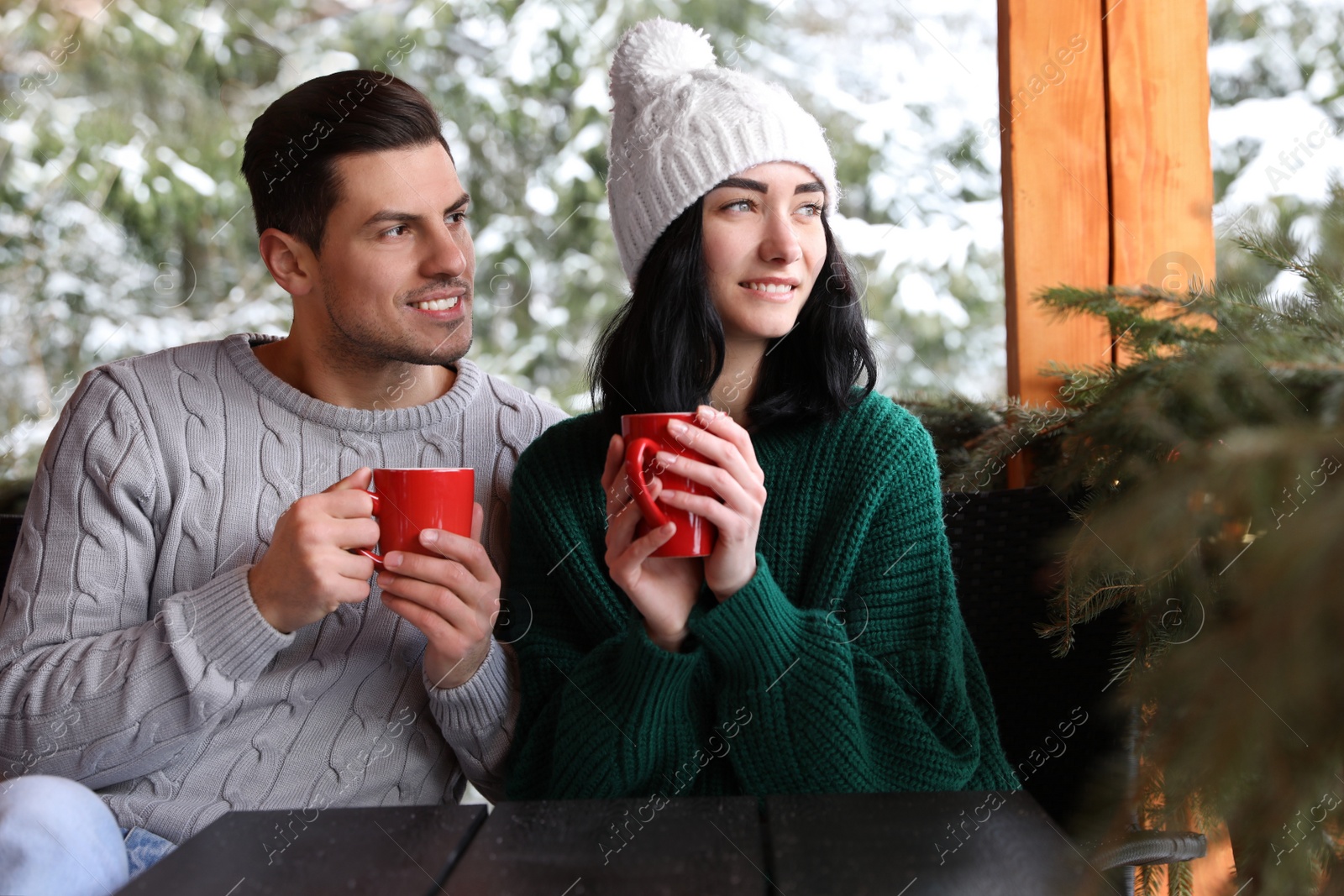 Photo of Happy couple in cafe near snowy forest. Winter vacation