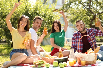 Photo of Young people enjoying picnic in park on summer day