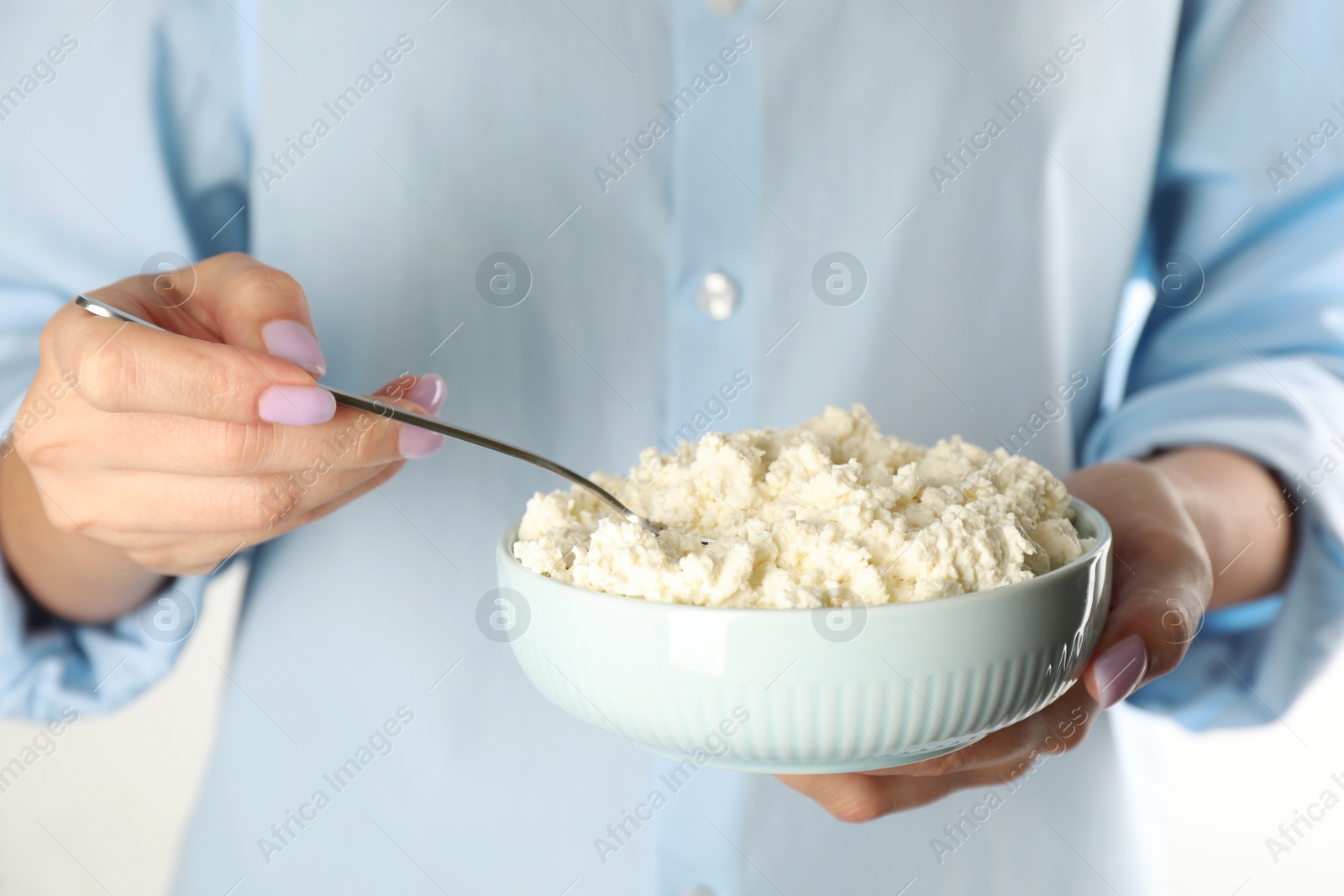 Photo of Woman with delicious fresh cottage cheese on white background, closeup