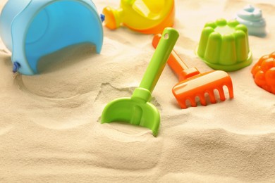 Photo of Colorful beach toy kit on sand. Outdoor play