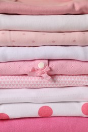 Photo of Stack of baby girl's clothes as background, closeup