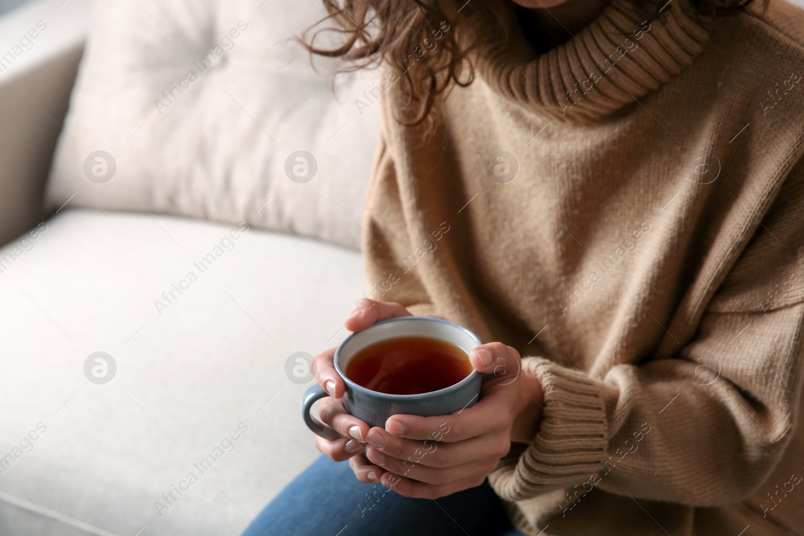 Photo of Woman with cup of hot tea indoors, closeup. Cozy home atmosphere