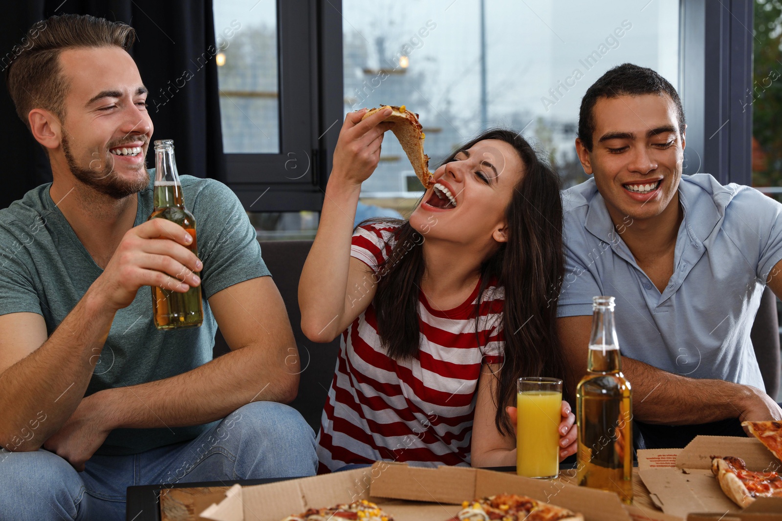 Photo of Group of friends having fun party with delicious pizza in cafe