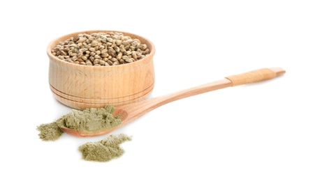 Spoon with hemp protein powder and bowl of seeds on white background