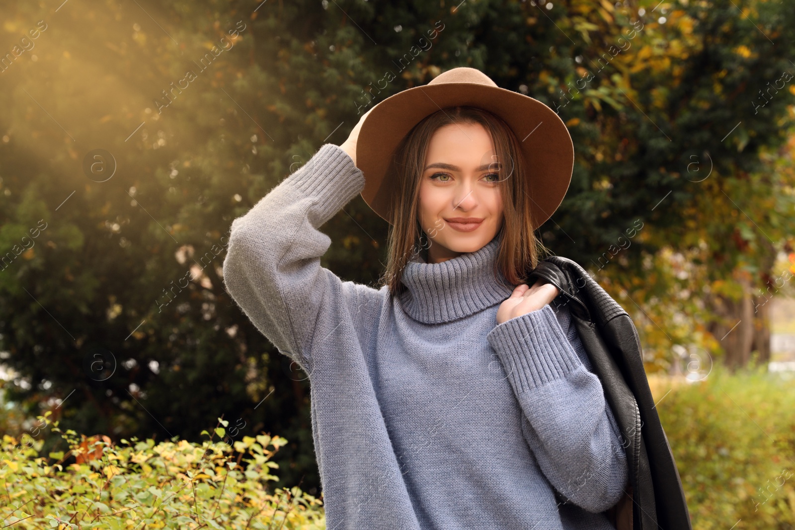 Photo of Beautiful young woman wearing stylish clothes in autumn park