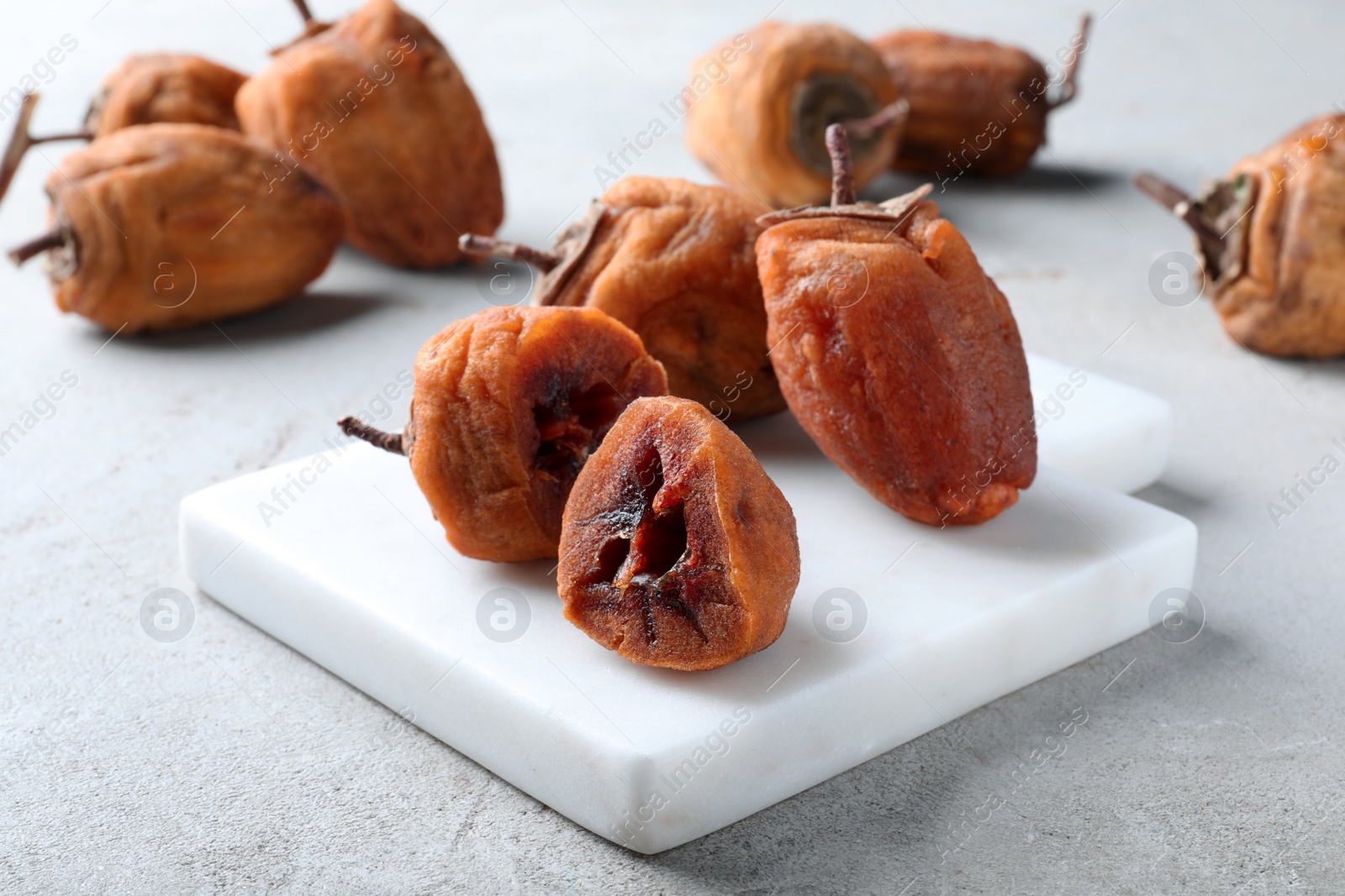 Photo of Many tasty dried persimmon fruits on light table