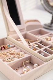 Jewelry box with stylish golden bijouterie on white table