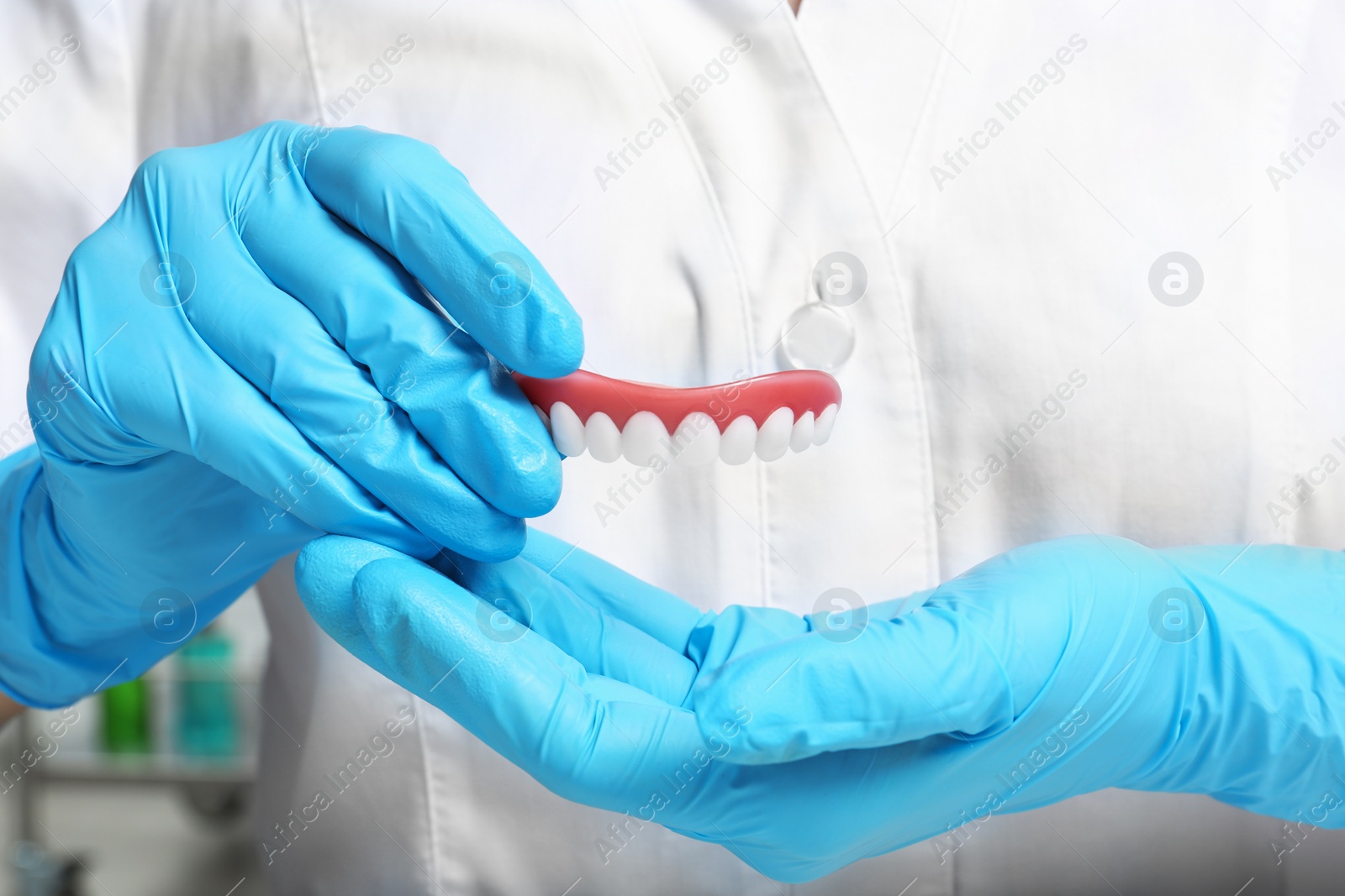 Photo of Dentist holding teeth cover, closeup view. Restorative dentistry