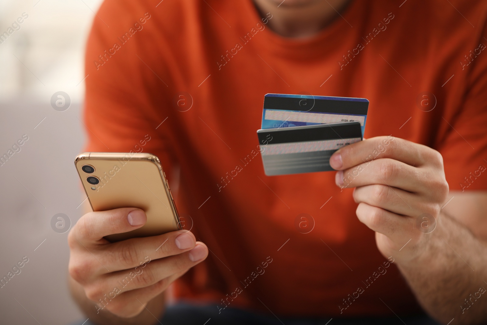 Photo of Man using smartphone and credit card for online payment, closeup