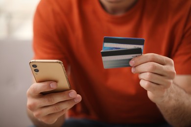 Photo of Man using smartphone and credit card for online payment, closeup