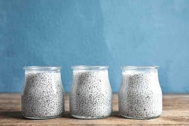 Photo of Jars of tasty chia seed pudding on table. Space for text