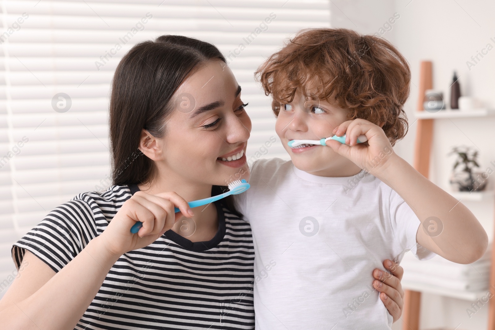 Photo of Mother and her son brushing teeth together in bathroom