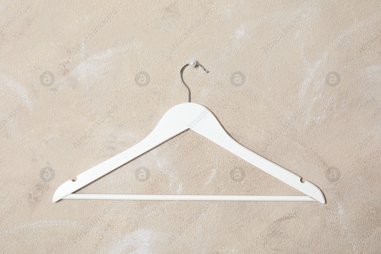 Photo of Empty clothes hanger on color wall. Wardrobe accessory