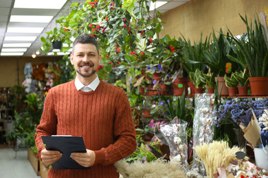 Photo of Male business owner with clipboard in his flower shop