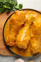 Tasty chicken curry and ingredients on grey textured table, flat lay