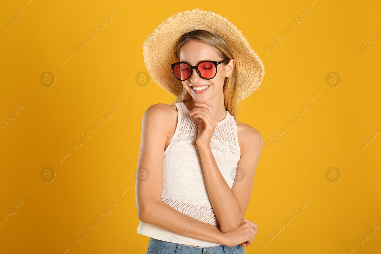 Photo of Beautiful woman in stylish sunglasses on yellow background