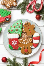 Tasty homemade Christmas cookies and decor on white wooden table, flat lay