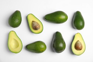 Photo of Cut and whole fresh ripe avocados on white background, top view