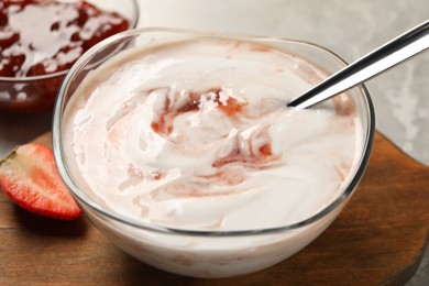 Tasty yoghurt with jam and strawberry on table, closeup