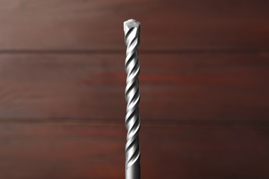 Photo of Closeup view of drill bit on wooden background